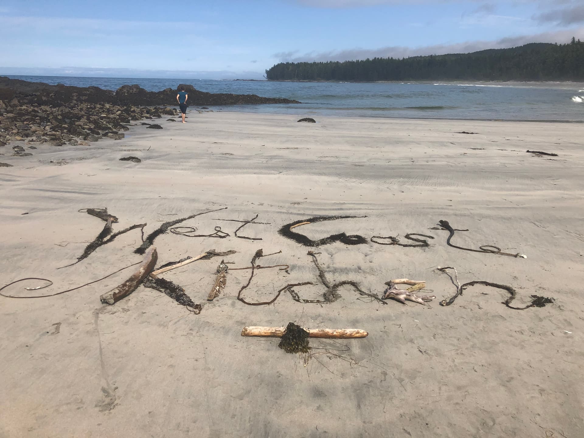 West Coast Kitchen spelled out in driftwood and seaweed on a BC beach